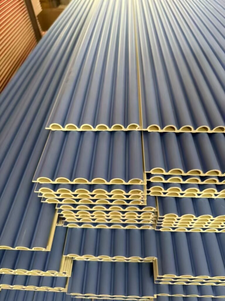 Bulk inventory of blue WPC semi-circle wave panels in a factory warehouse, showcasing the high-density circular fluted profile for large-scale commercial interior wall projects.