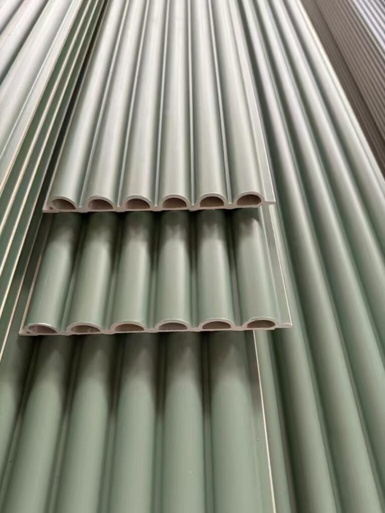 Stack of mint green WPC semi-circle wave panels in factory, featuring a soothing pale green finish and rounded fluted profile for modern eco-friendly interior wall decor.