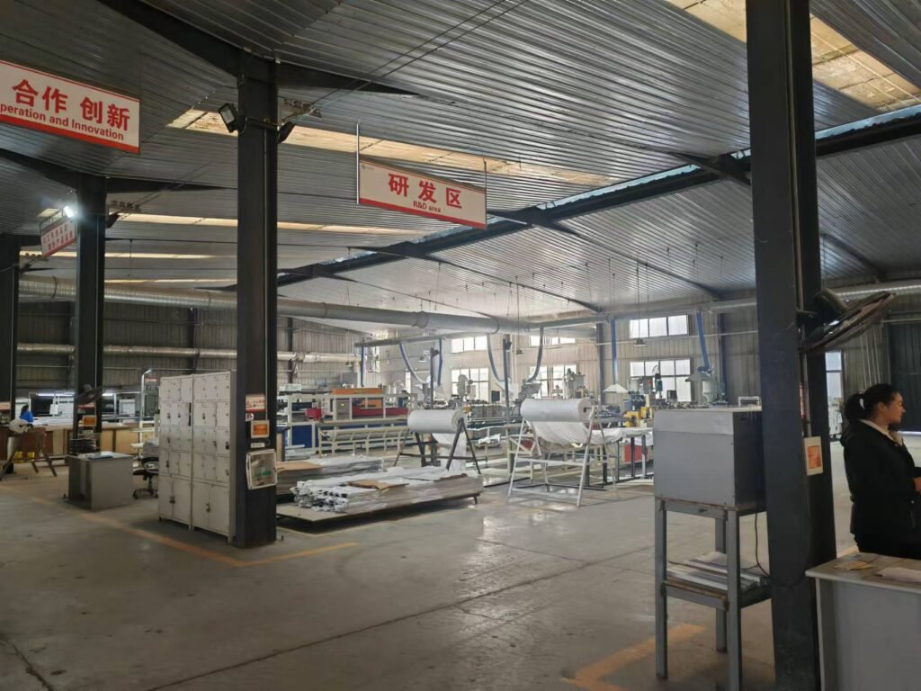 Industrial view of an automated PVC marble sheet and UV board production line, featuring specialized machinery for high-gloss surface coating and luxury stone texture extrusion in a large-scale manufacturing facility.
